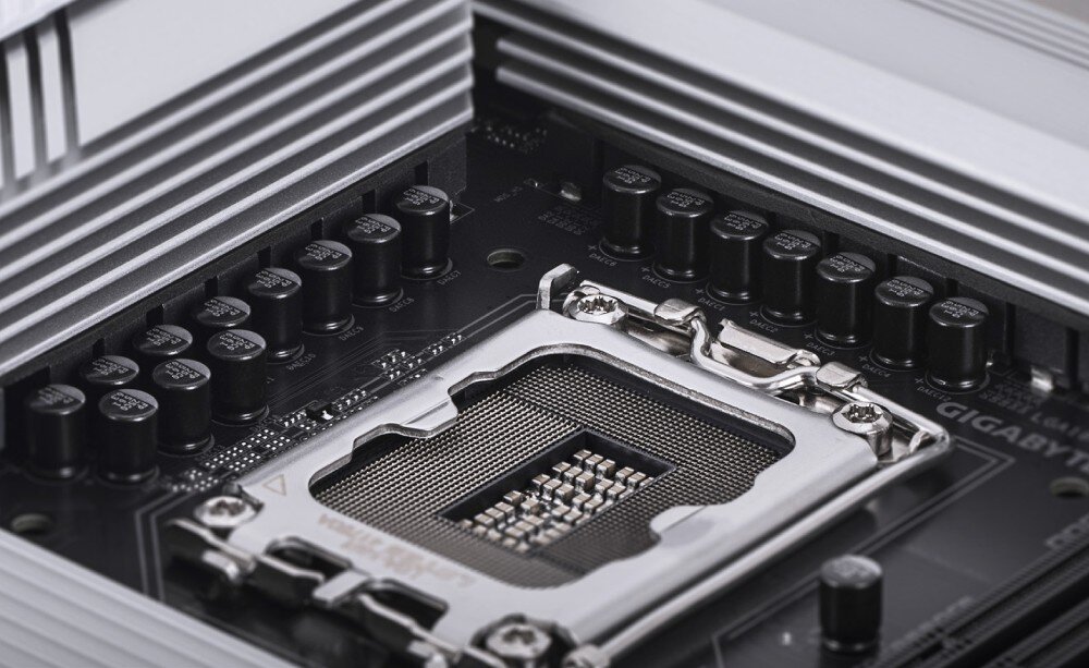 Płyta główna GIGABYTE Z890 Gaming X WiFi7 Zbliżenie na gniazdo procesora z widocznymi pinami i metalowym mocowaniem otoczone sekcją zasilania z czarnymi kondensatorami i radiatorami, kompatybilność, procesory, układ zasilania