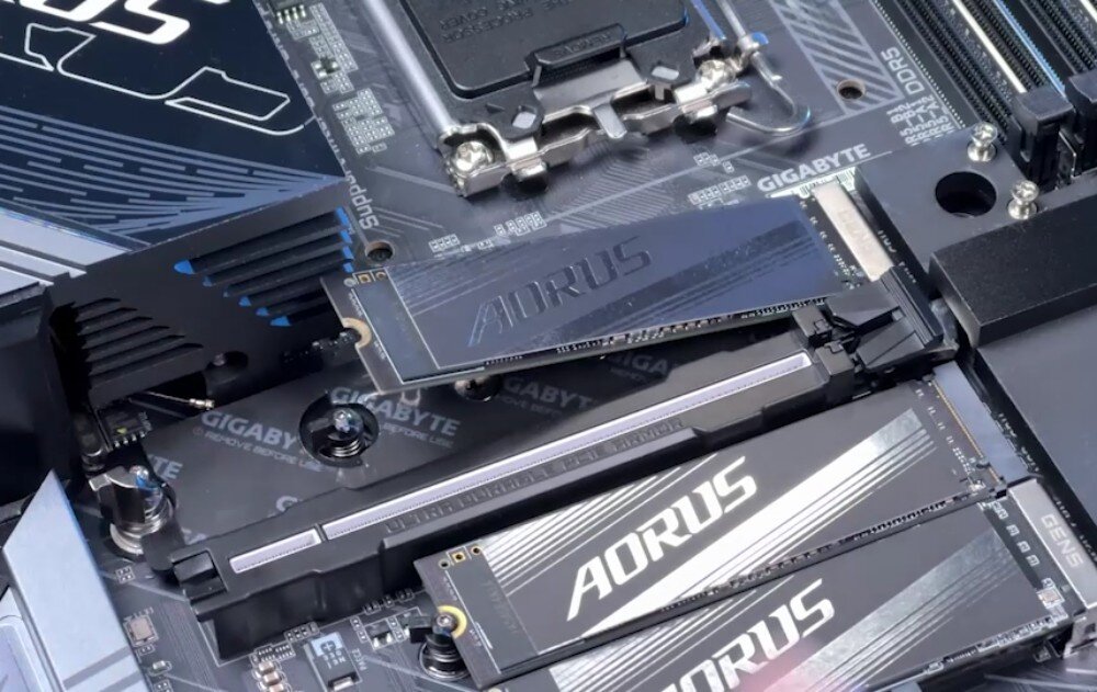Płyta główna GIGABYTE Z890 Gaming X WiFi7 Zbliżenie na obszar płyty głównej z trzema zamontowanymi dyskami M.2 z widocznymi radiatorami z napisem 'AORUS', montaż