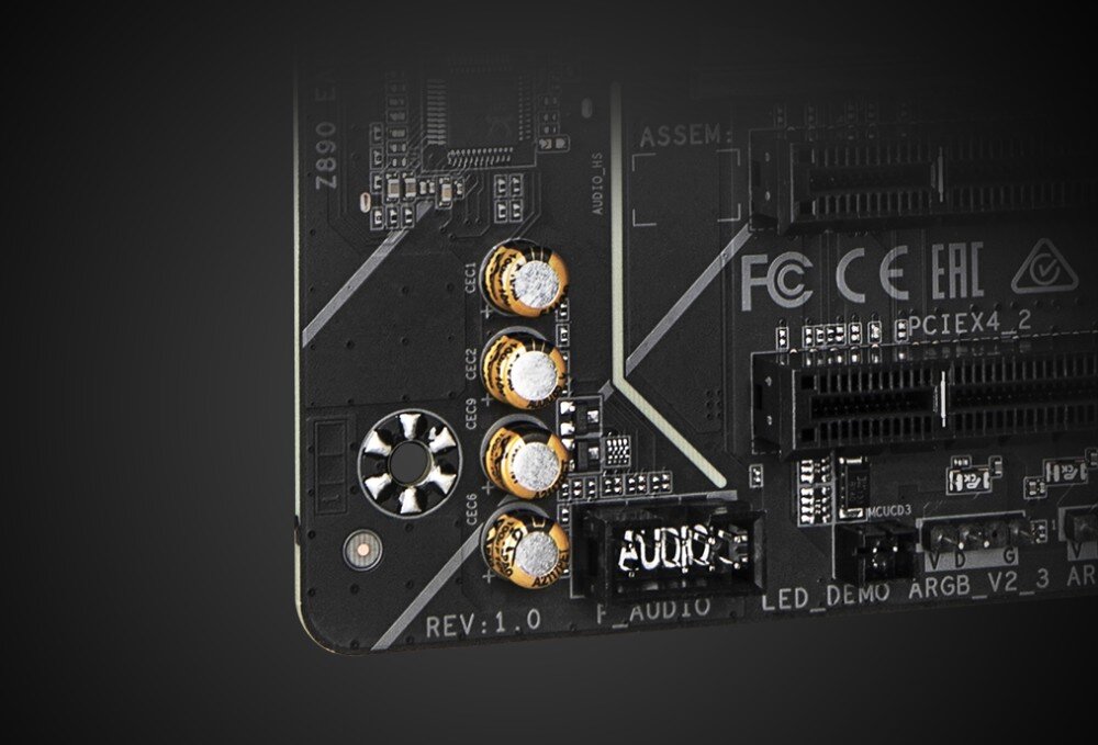 Płyta główna GIGABYTE Z890 Eagle WiFi7 Dolny fragment płyty głównej z czterema złotymi kondensatorami w sekcji audio i widocznymi oznaczeniami technicznymi, układ audio, dźwięk