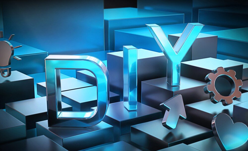 Płyta główna GIGABYTE Z890M Aorus Elite WiFi7 Ice Trójwymiarowy napis 'DIY' ułożony z metalicznych liter na klockach wraz z ikonami żarówki, serca i koła zębatego