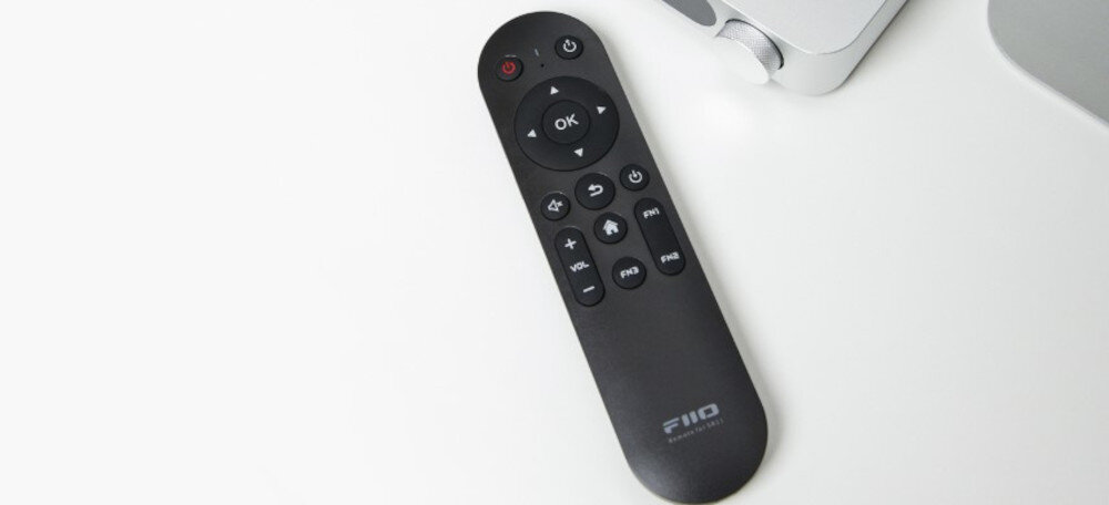 Odtwarzacz sieciowy FIIO SR11 pilot zdalne sterowanie funkcje wejścia wyjścia głośność, pilot na białym blacie