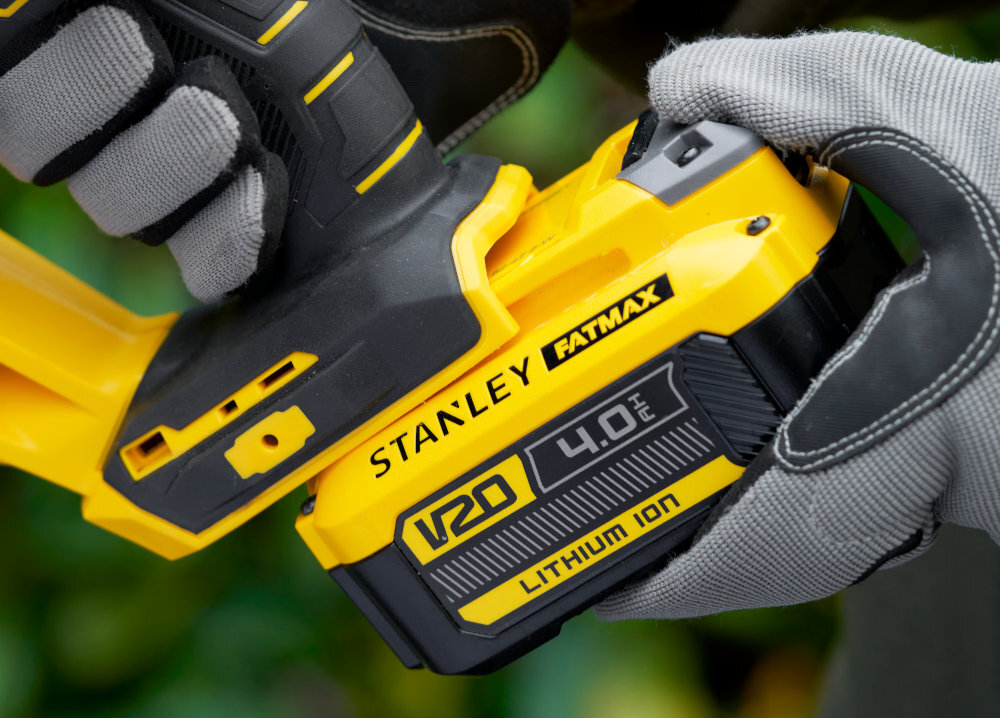Nożyce do żywopłotu STANLEY SFMCHT855B-XJ 550mm 18V akumulatorowe osoba trzyma nożyce w dłoniach wkłada akumulator na miejsce akumulator z serii STANLEY Fatmax V20 brak efektu pamięci niskie samorozładowanie pełna swoboda ruchu pracy w dowolnym miejscu ogrodu wspólny system zasilania STANLEY Fatmax V20 jeden akumulator w wielu narzędziach