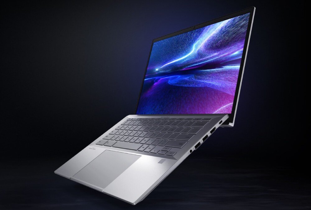 Laptop ASUS ExpertBook CX5403CMA-QM0137 Srebrny laptop widziany z boku na ciemnym tle; ekran pokazuje dynamiczną, świetlną grafikę w fioletowych i niebieskich barwach, ekran, rozdzielczość, przekątna, matryca