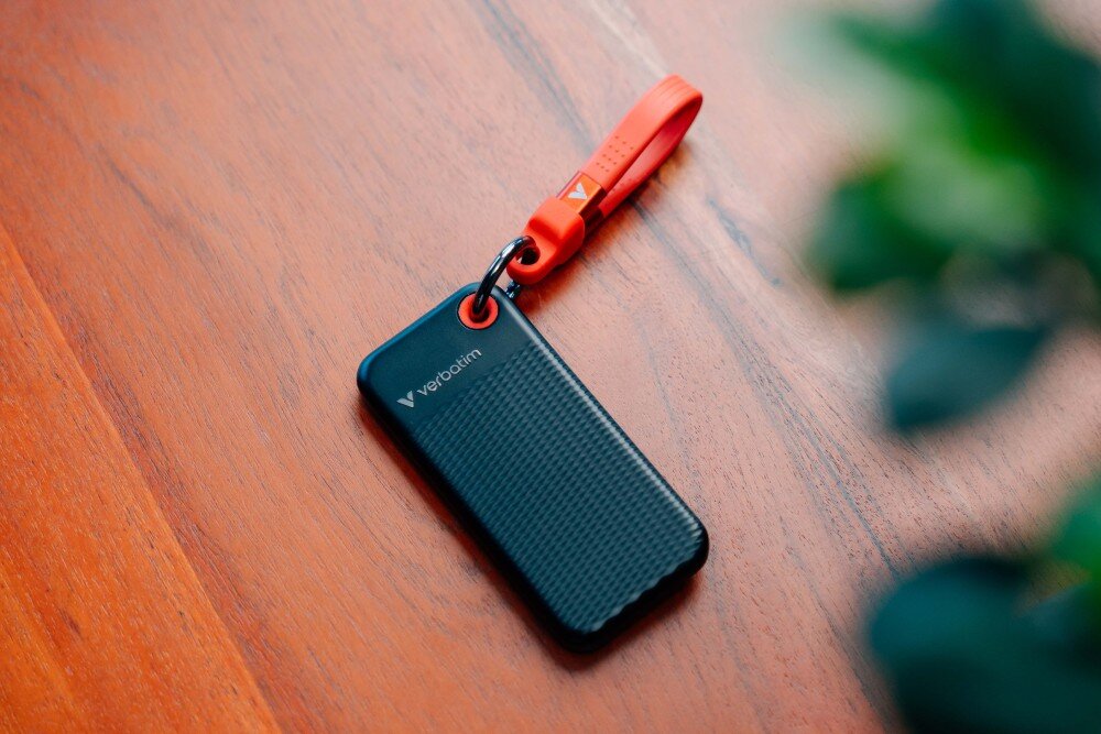 Dysk VERBATIM Pocket 1TB SSD Czarno-czerwony rzut z góry na dysk leżący na drewnianej powierzchni opis