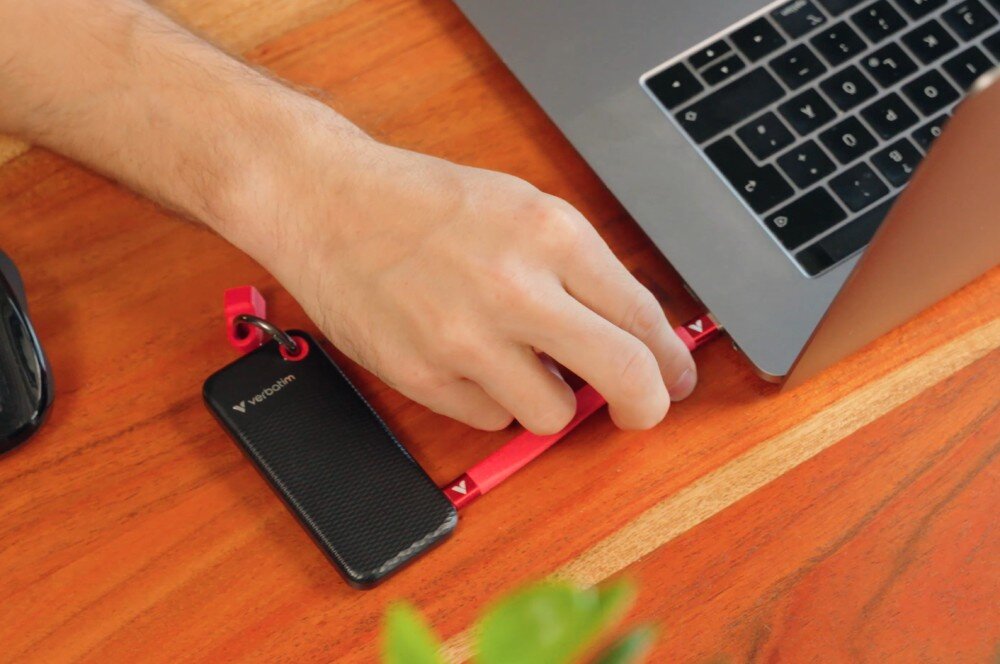 Dysk VERBATIM Pocket 1TB SSD Czarno-czerwony dysk leżący na biurku podłączony do laptopa interfejs prędkość podłączenie kabel kompatybilność