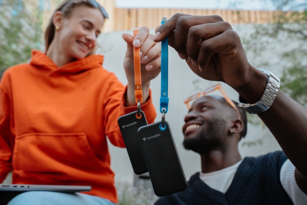 Dysk VERBATIM Pocket 2TB SSD Czarno-niebieski osoba trzymająca dysk, do którego przymocowany jest brelok technologia SSD wytrzymałość zalety