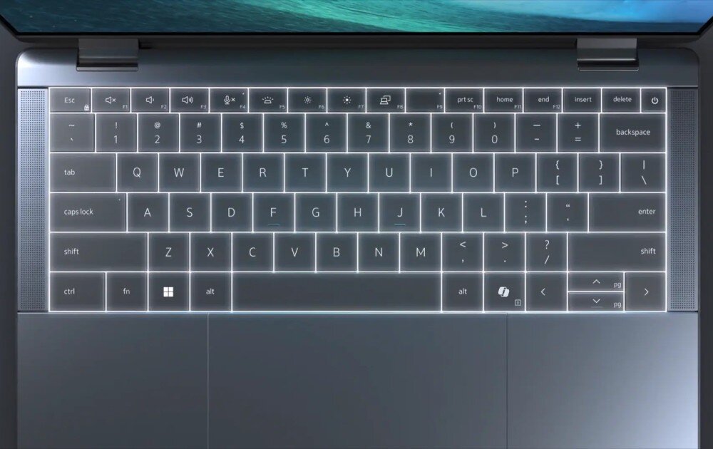 Laptop DELL Latitude 9450 Zbliżenie na klawiaturę laptopa z podświetleniem, pokazującą układ klawiszy i ich jasne obramowanie na ciemnym tle, budowa, wielkość, materiał, klawiatura