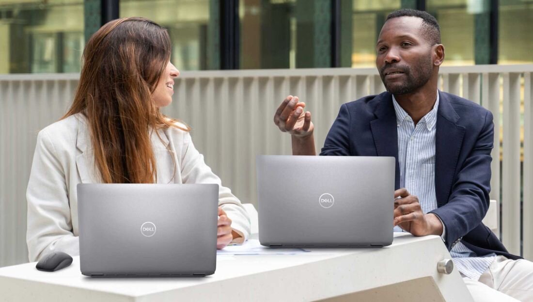 Dwie osoby przy stole, korzystające z laptopów Dell Latitude 5550. - Wyraźna komunikacja, Funkcja Intelligent Audio