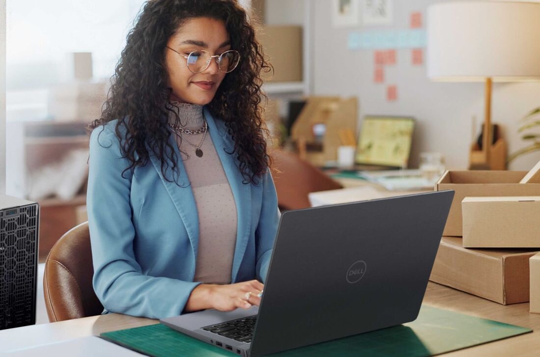 Kobieta w niebieskim żakiecie pracuje na laptopie DELL Latitude 7450. - Trzypoziomowa jednostka wieloprocesorowa