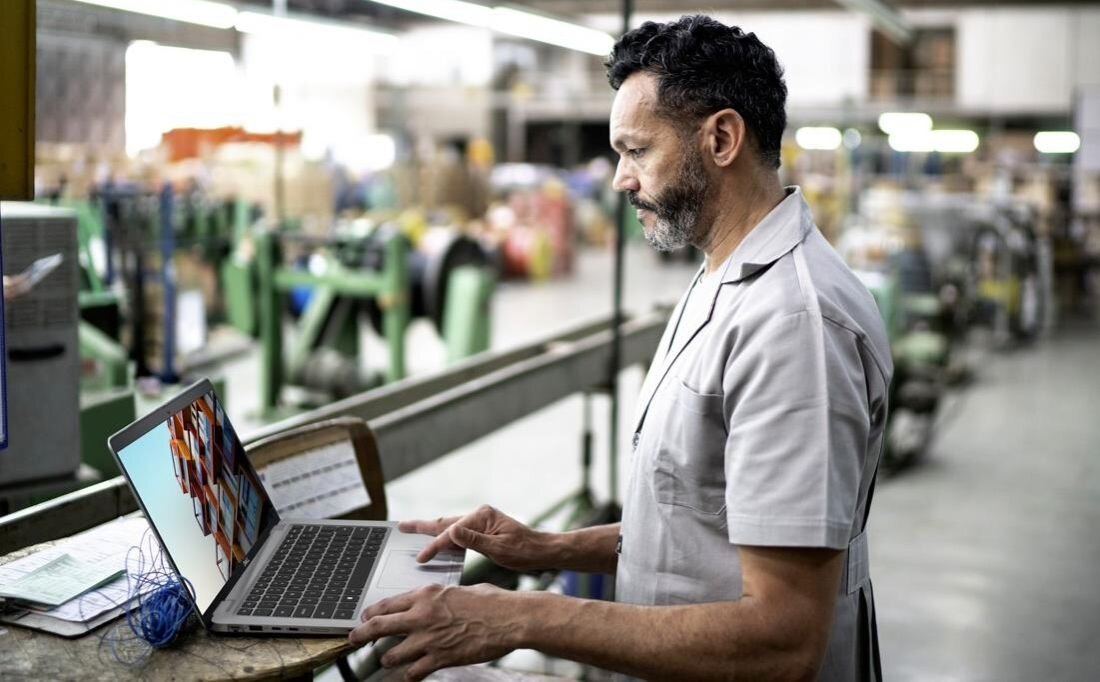 Mężczyzna pracujący na laptopie DELL Latitude 5440 w fabryce, skupiony na zadaniach. - procesor Intel Core
