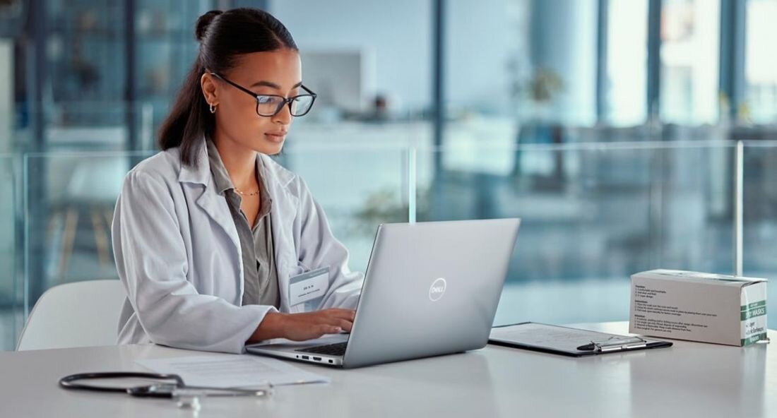 Kobieta w fartuchu laboratoryjnym pracuje na laptopie DELL Latitude 5440, skupiona na ekranie. - dysk SSD PCIe NVMe 4.0