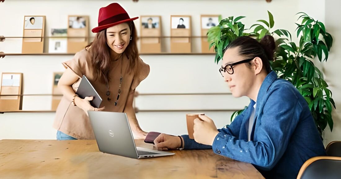 Mężczyzna i kobieta siedzą przy stole z laptopem, rozmawiając i pracując razem. - zrównoważony rozwój i efektywność energetyczna 