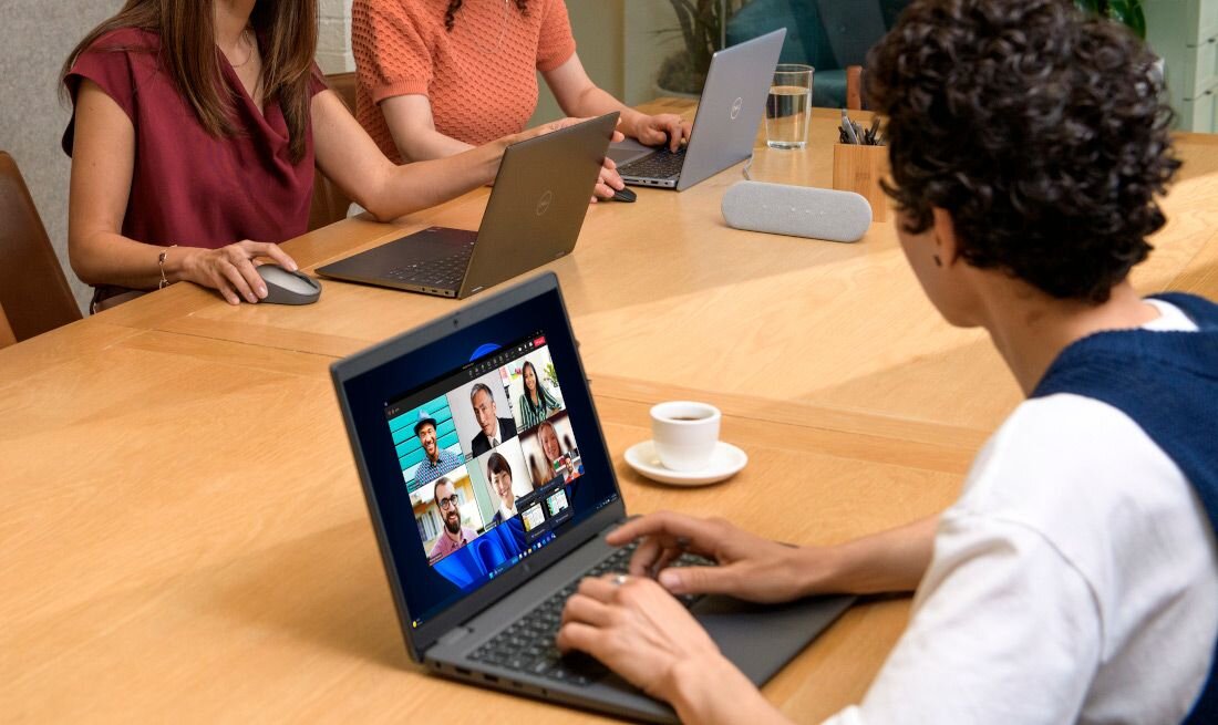 Spotkanie biznesowe z trzema osobami pracującymi na laptopach DELL Latitude podczas wideokonferencji przy dużym drewnianym stole i filiżance kawy. - procesor Intel Core Zintegrowany układ 