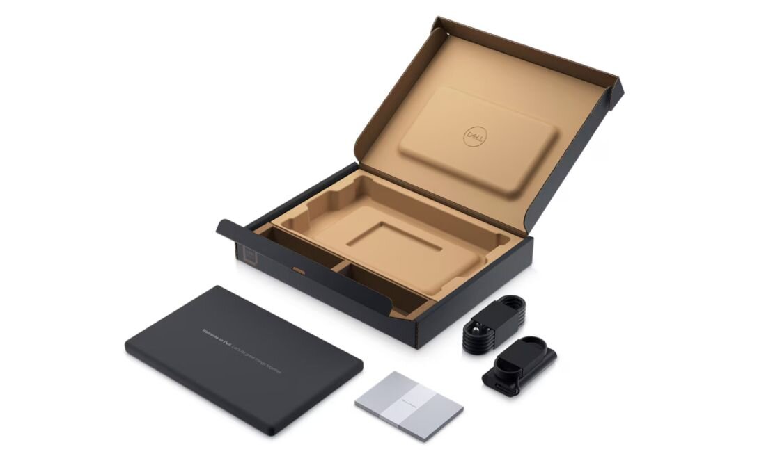 Ekologiczne opakowanie Dell Latitude z wkładką z masy papierowej oraz ułożonym zasilaczem, okablowaniem i dokumentacją obok pustego pudełka. - Materiały z recyklingu