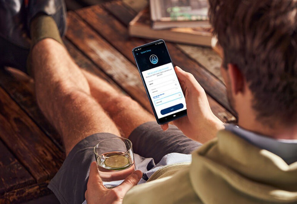 Router ASUS RT-AX57 Go AX3000 Widok z góry na osobę trzymającą smartfon z wyświetlonym ekranem konfiguracji konta lokalnego w aplikacji do zarządzania routerem