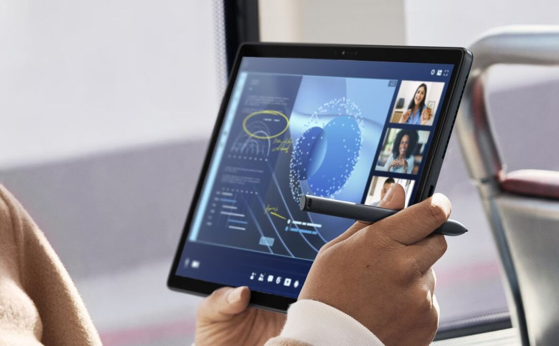 Kobieta w beżowym swetrze trzymająca tablet DELL Latitude 7350 z rysikiem podczas wideokonferencji biznesowej, ekran pokazujący trzy uczestników spotkania online i zaawansowane wykresy danych z kolorową grafiką 3D w kolorach niebieskim i pomarańczowym, narzędzie dla pracy zdalnej i prezentacji - Intel Core Ultra Jednostka NPU Pamięć RAM LPDDR5X Dysk SSD 