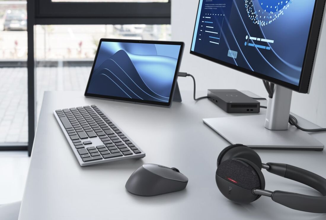 Przestronne stanowisko pracy z tabletem DELL Latitude 7350 na stojaku podłączonym do monitora zewnętrznego z wizualizacją danych, pełnowymiarowa klawiatura bezprzewodowa, mysz ergonomiczna, słuchawki do wideokonferencji, stacja dokująca USB-C, białe biurko z roślinami doniczkowymi, rozwiązanie dla profesjonalistów i multitaskingu  - USB, HDMI, DisplayPort i Ethernet 