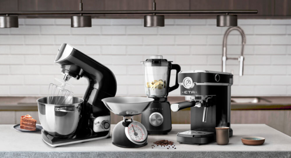 Blender kielichowy ETA Storio 901190030 Czarny jasne tło czarne sprzęty stoją na ciemnym blacie mikser z misą waga ekspres blender cicha praca zaledwie 75 dB(A) intuicyjny panel sterowania ergonomiczny uchwyt Długość kabla wynosząca 1,2 metra wydajność bezpieczeństwo elegancki wygląd 