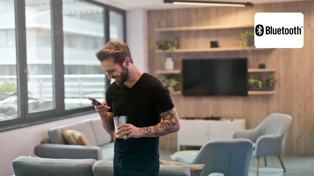 Telewizor HYUNDAI ULX65359GSMART - Chromecast, Bluetooth, Wi-Fi, osoba trzymająca telefon w dłoni