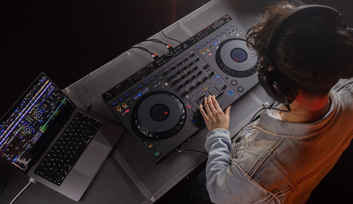 Kontroler DJ ALPHA THETA DDJ-GRV6 - Szybka selekcja utworów, kontorler podłaczony do laptopa, osoba obsługujaca urządzenie