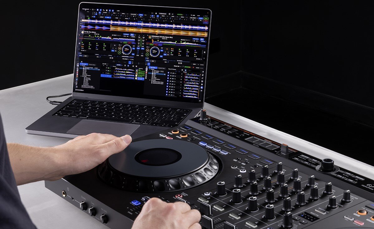 Kontroler DJ ALPHA THETA DDJ-GRV6 - Elastyczność w oprogramowaniu, kontorler podłaczony do laptopa, osoba obsługujaca urządzenie