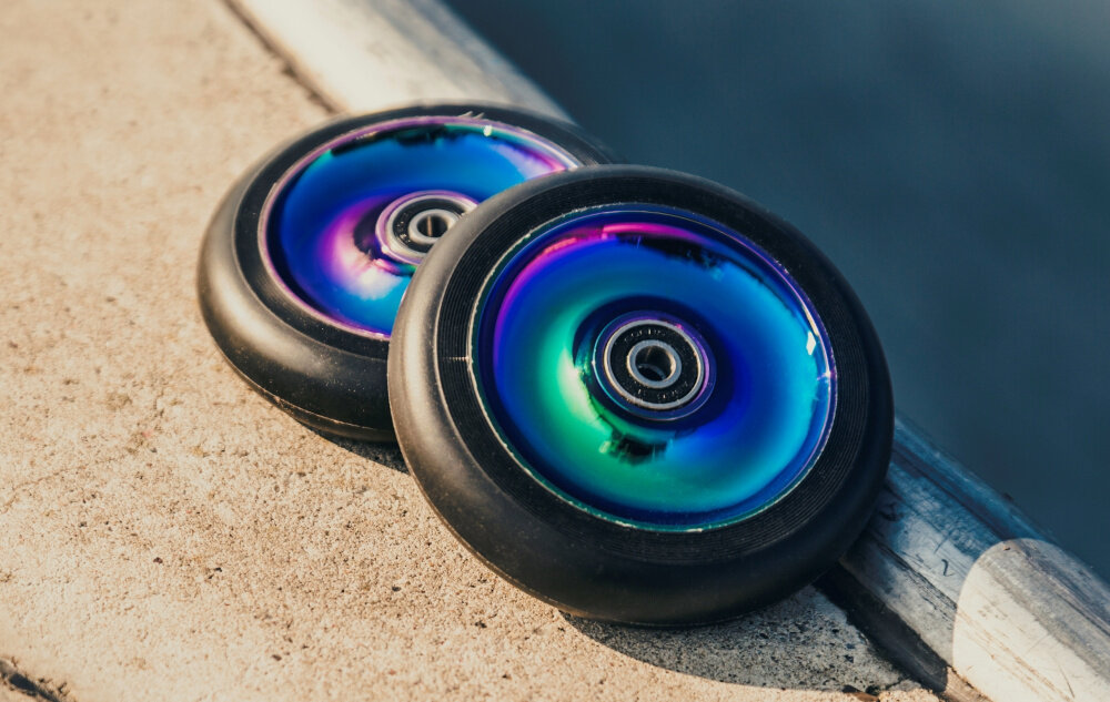 Hulajnoga wyczynowa LIONELO Whizz Wielokolorowy Czarno-fioletowy wysokiej jakosci kolka PU z serii High Rebound sredcnia 110 mm twardosc 90A przyczepnosc stabilnosc plynnosc zaawansowane lozyska ABEC-9