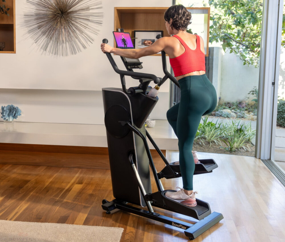 Orbitrek magnetyczny BOWFLEX SEi Max Trainer osoba trenuje na maszynie w pomieszczeniu efektywny trening całego ciała trening cardio w domu poprawa kondcji spalanie kalorii dbanie o zdrowie