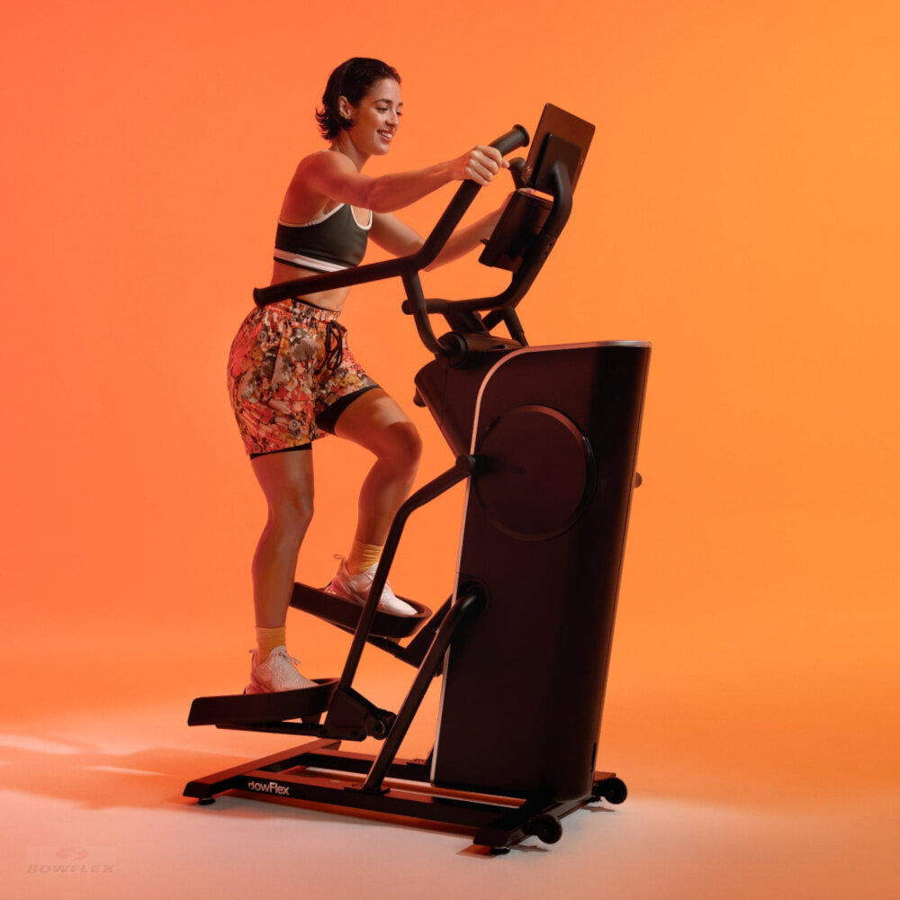 Orbitrek magnetyczny BOWFLEX SEi Max Trainer osoba trenuje na maszynie na kolorowym tle 16 poziomów oporu magnetycznego płynne dostosowanie intensywności treningu cicha płynna praca komfortowe ćwiczenia w domowym zaciszu stopniowe zwiększanie trudności