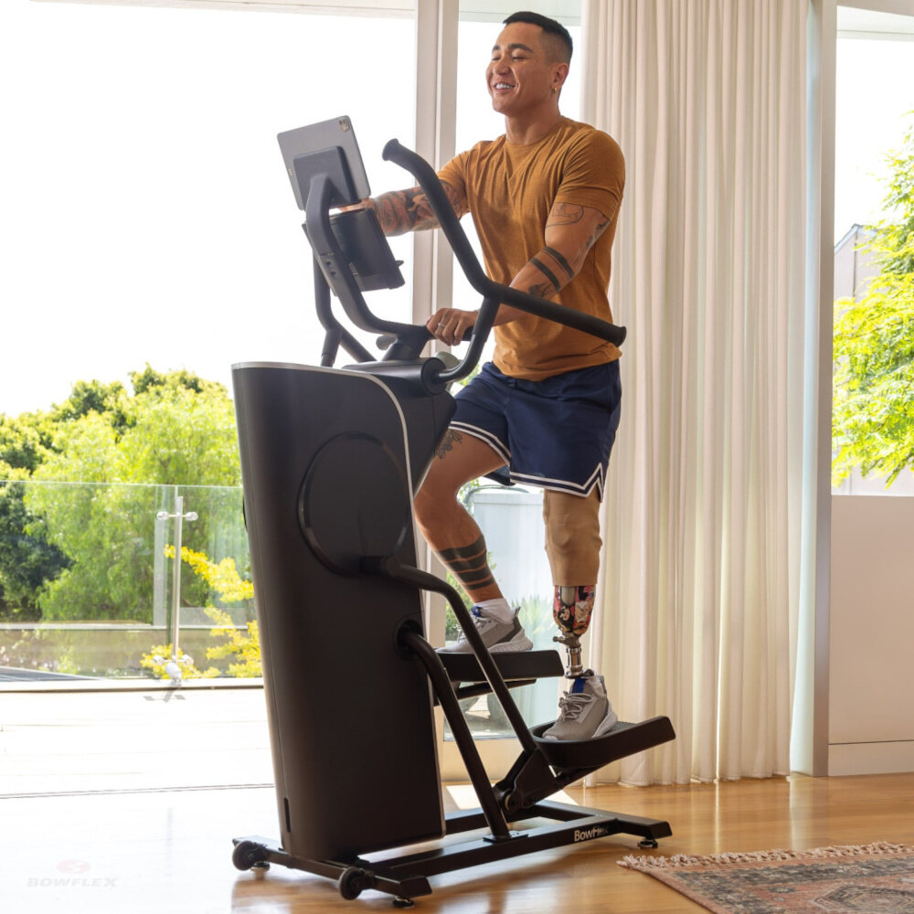 Orbitrek magnetyczny BOWFLEX SEi Max Trainer osoba trenuje na maszynie w pomieszczeniu aplikacja Bowflex JRNY spersonalizowane programy treningowe program Sprint 8 HIIT dostosowanie poziomu oporu monitorowanie postępów