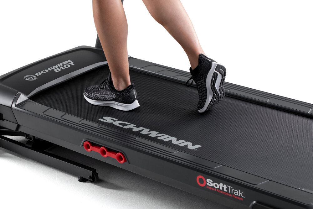 Bieżnia elektryczna SCHWINN 510T 1939W 16km-h zbliżenie na pas biegowy osoba biegnie po bieżni pas biegowy o wymiarach 51 x 140 cm stabilność wygoda system amortyzacji redukuje obciążenie stawów dla osób rozpoczynających aktywność fizyczną dla doświadczonych biegaczy amortyzowane podłoże