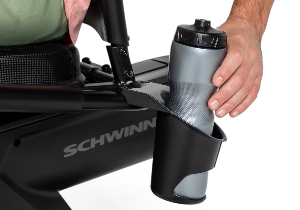 Rower magnetyczny SCHWINN R590 osoba wkłada bidon w uchwyt wygoda innowacyjne technologie efektywny trening poprawa kondycji wzmocnienie mięśni óg aktywność bez wychodzenia z domu uchwyt na bidon