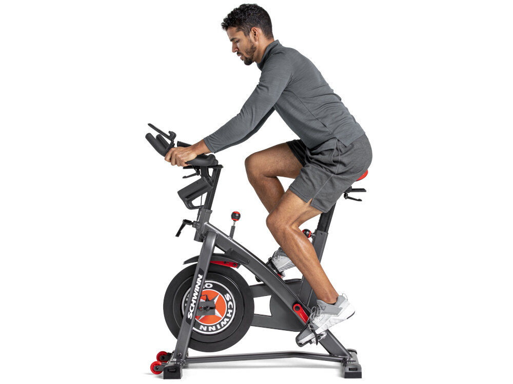 Rower spiningowy SCHWINN Indoor Cycling Schwinn 800IC osoba jedzie na rowerze na białym tle widok z boku intensywny trening w domu precyzyjna regulacja oporu wysoka jakość komponentów poprawa kondycji spalanie kalorii