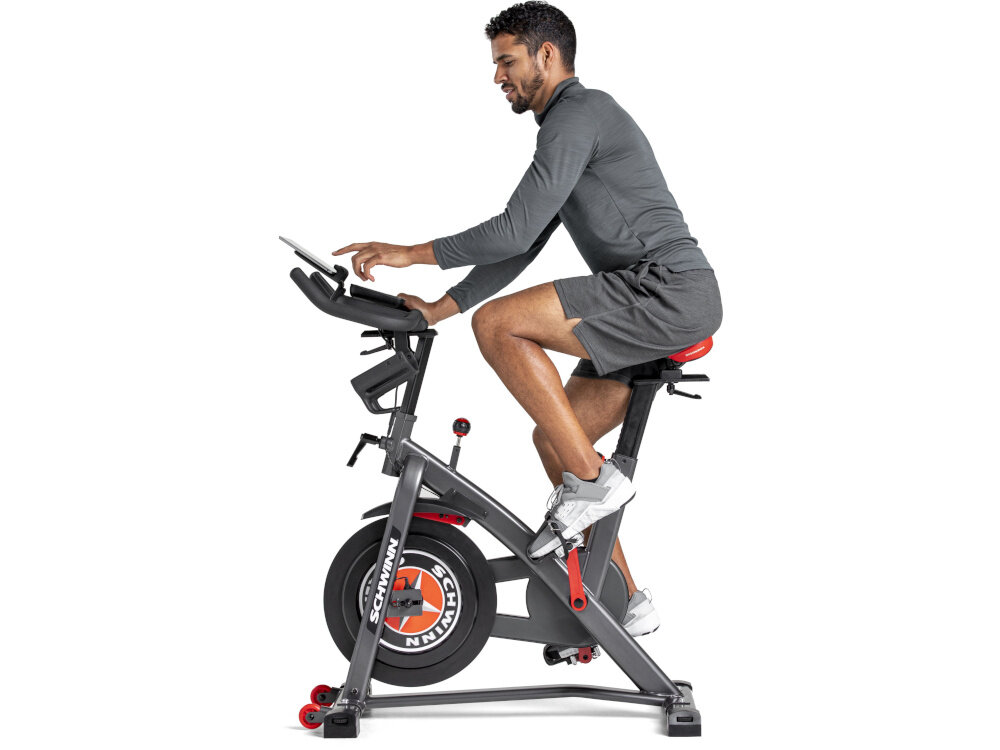 Rower spiningowy SCHWINN Indoor Cycling Schwinn 800IC osoba jedzie na rowerze na białym tle widok z boku funkcja pomiaru pulsu monitorowanie efektów treningu kotrolowanie poziomu wysiłku