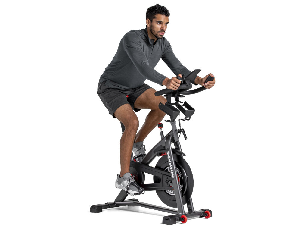 Rower spiningowy SCHWINN Indoor Cycling Schwinn 800IC osoba jedzie na rowerze na białym tle widok pod skosem regulacja siodełka i kierownicy odpowiednie dopasowanie do postawy ciała komfortowe warunki