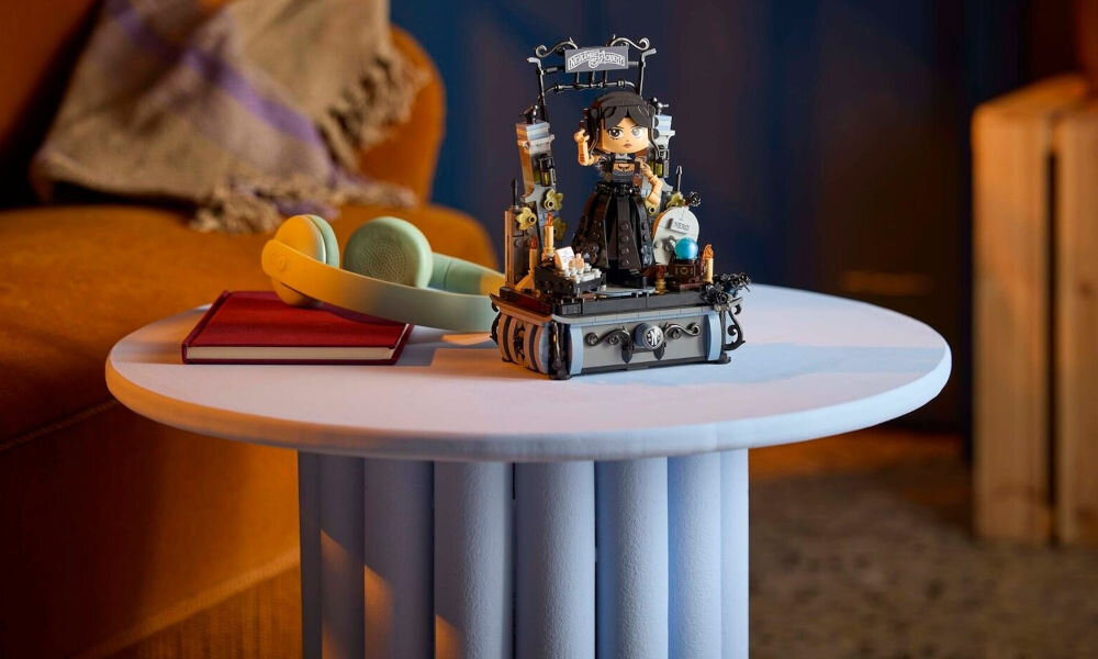 LEGO 76780 Wednesday Figurka Wednesday Addams stojąca w bramie akademii Nevermore na białym stoliku w pokoju