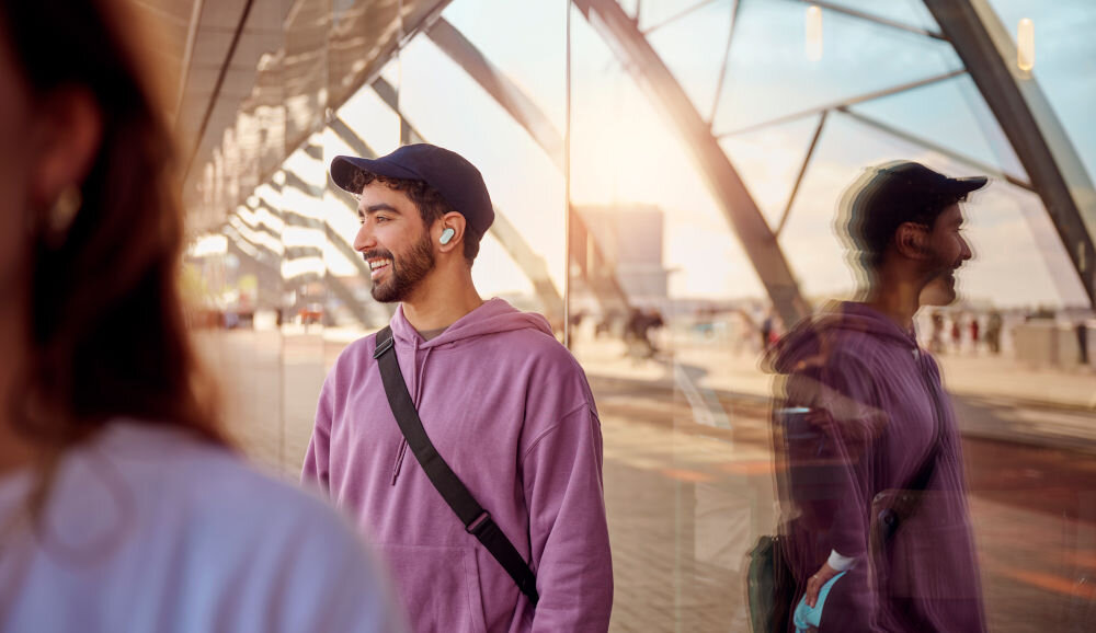 Słuchawki dokanałowe PHILIPS TAT3509GY/00, dotykowe sterowanie, aplikacja Philips Headphones, osoba z założonymi słuchawkami dokanałowymi w plenerze