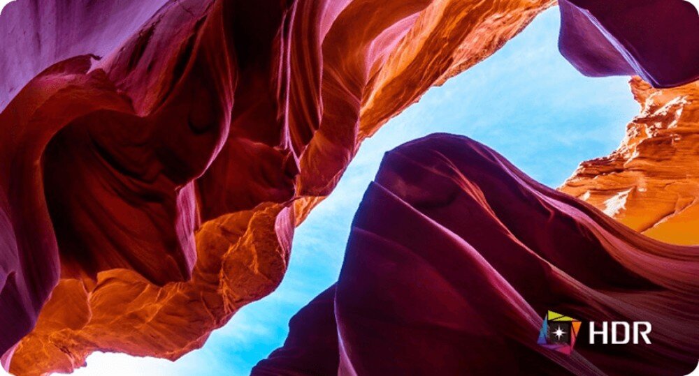 Obraz przedstawia kolorowe formacje skalne z widocznym niebem w tle. W prawym dolnym rogu znajduje się logo z napisem \'HDR\'.