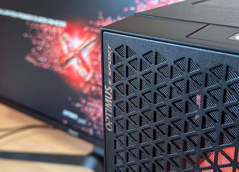 Komputer OPTIMUS E-sport GA520T-CR4 Zestaw komputerowy na biurku: monitor z czerwoną grafiką na ekranie, klawiatura, myszka na podkładce i obudowa z dwoma frontowymi wentylatorami w kolorze żółtym, podzespoły, cechy, zalety