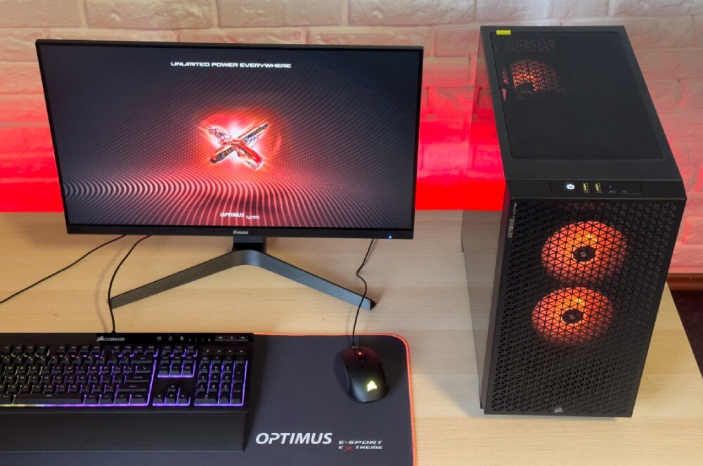 Komputer OPTIMUS E-sport GA520T-CR4 Zbliżenie na górny panel obudowy komputera z przyciskiem zasilania, dwoma żółtymi portami USB, gniazdem słuchawkowym i siatką wentylacyjną, porty, gniazda, podłączenie