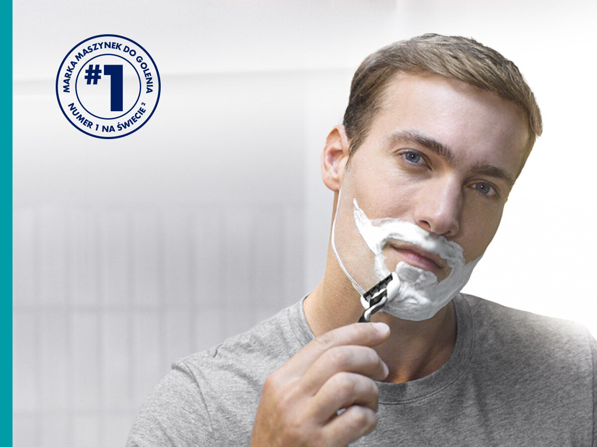 Ostrza do golarki GILLETTE Mach3 (8 szt.) Mężczyzna goli twarz maszynką Gillette Mach3, na twarzy ma piankę do golenia. W lewym górnym rogu okrągły znaczek z tekstem 'MARKA MASZYNEK DO GOLENIA #1 NUMER 1 NA ŚWIECIE' w języku polskim.