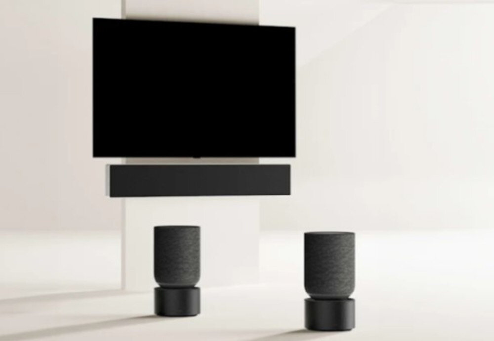 Soundbar BANG & OLUFSEN Beosound Stage - Dolby Atmos dla immersjim soundbar powieszony na ścianie z telewizorem. głośniki w tle