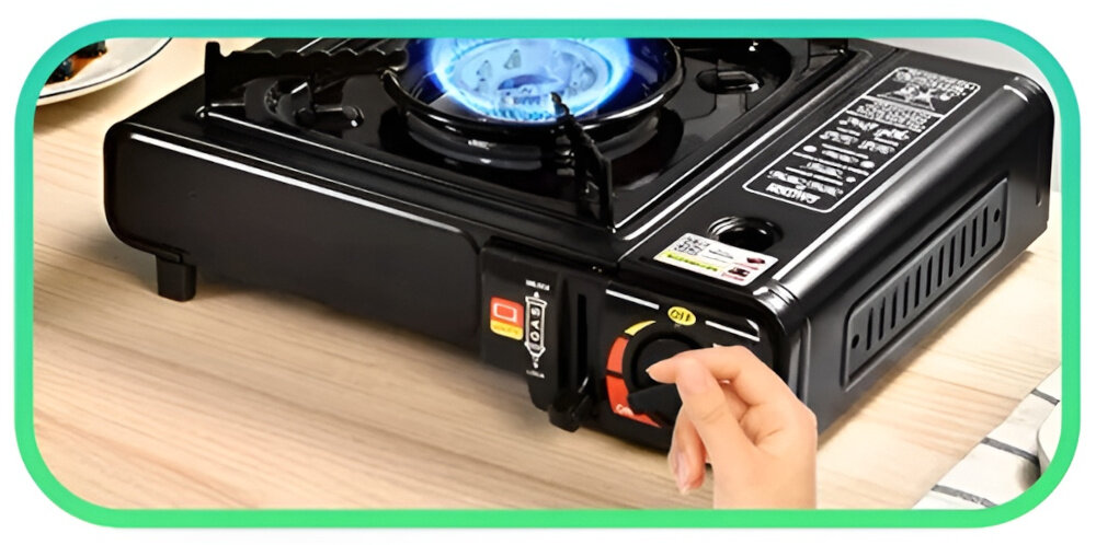 Kuchenka turystyczna EXTRALINK EX.39500 zbliżenie na pokrętło do regulacji osoba zbliża dłoń do pokrętła drewniany blat możliwość regulacji siły płomienia można dopasować intensywność gotowania do rodzaju potrawy i potrzeb użytkownika kontrolowanie temperatury