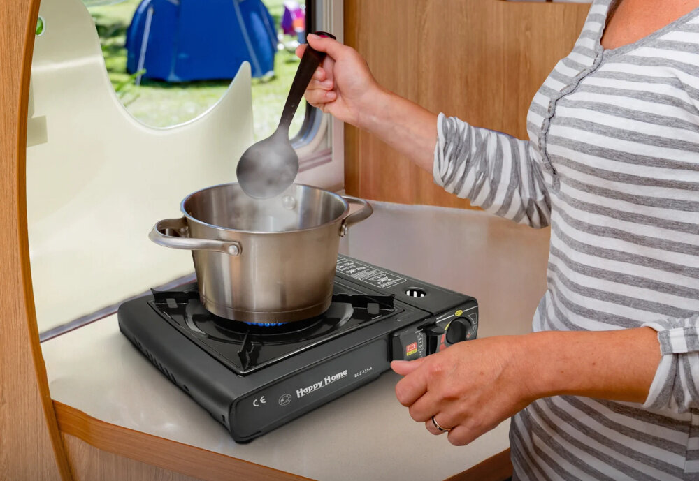 Kuchenka turystyczna EXTRALINK EX.39500 kamping drewniany blat kuchenka na blacie na kuchence garnek osoba miesza łyżką w garnku palnik o średnicy 8,5 cm równomierne rozprowadzanie ciepła jedzenie zachowuje odpowiednią strukturę i temperaturę komfort użytkowania