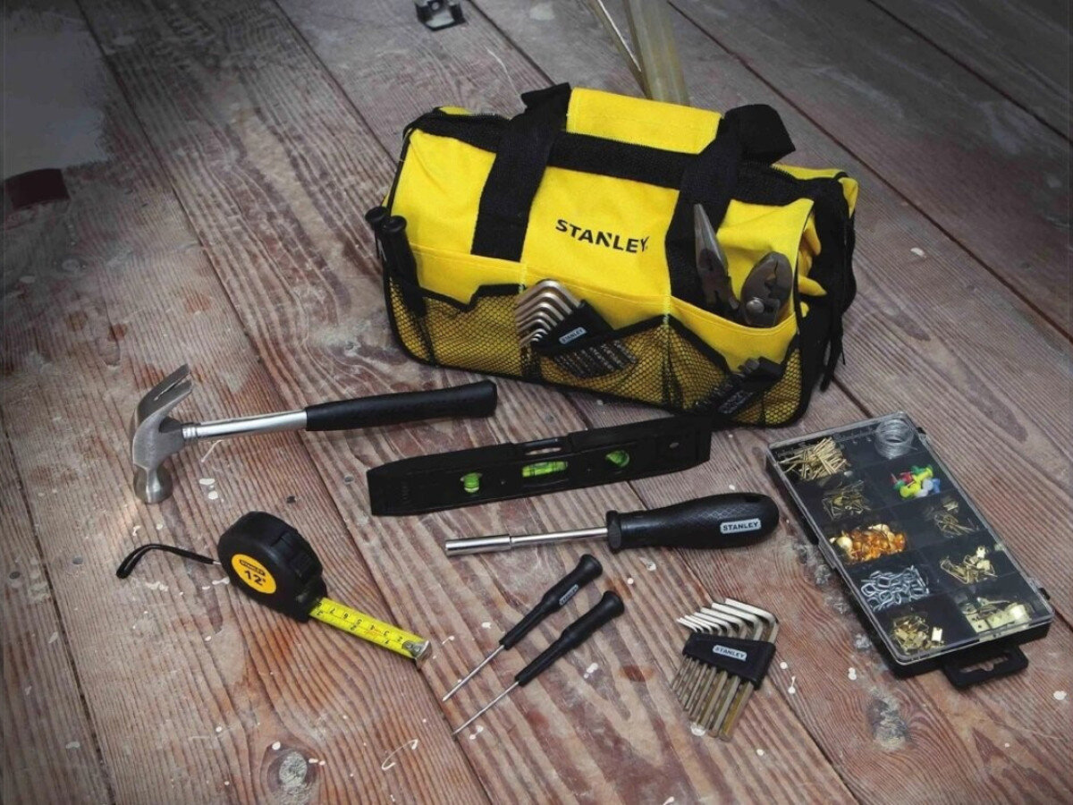Zestaw narzędzi STANLEY STMT0-74101 (38 elementów), narzędzia, precyzja, funkcjonalność, jakość, Torba Stanley z narzędziami: młotek, poziomica, śrubokręty, nakrętki na stole.