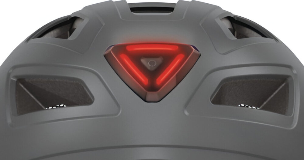 Kask rowerowy ABUS Hyban 2.0 Tytanowy Miejski rozmiar XL zbliżenie na świecącą lampkę czerwona lampka zintegrowane tylne światło LED o widoczności 180° liczne mocne odblaski bezpieczeństwo