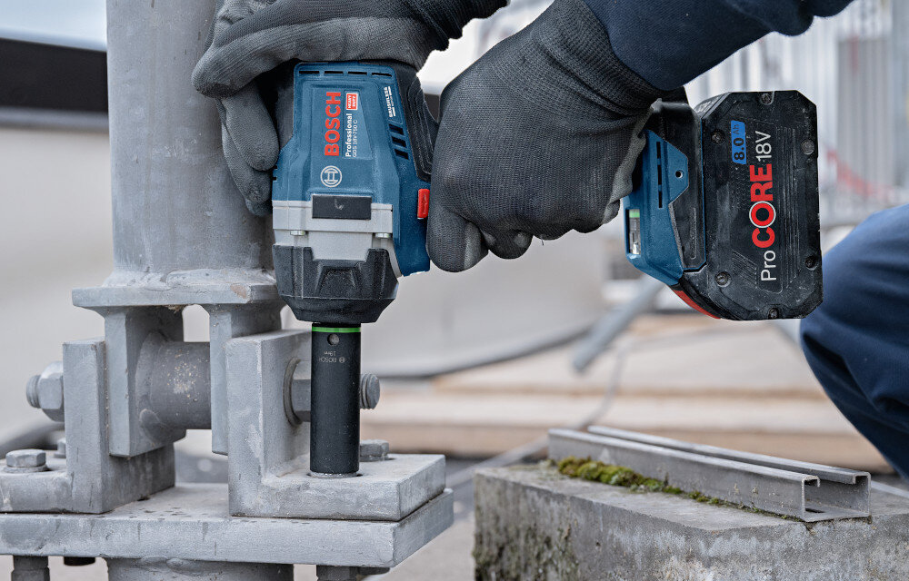 Klucz udarowy BOSCH GDS 18V-750 plac budowy osoba dokręca śruby w metalowych elementach praca w betonie funkcja udaru od 0 do 3000 uderzeń na minutę trzystopniowa regulacja (0-1500 ud/min, 0-2300 ud/min, 0-3000 ud/min) dopasowanie parametrów do różnych zadań