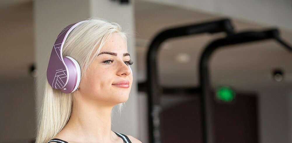 PowerLocus P2 lekkie słuchawki 165g pianka memory foam ergonomiczny pałąk komfortowe nauszne, osoba z założonymi słuchawkami nausznymi