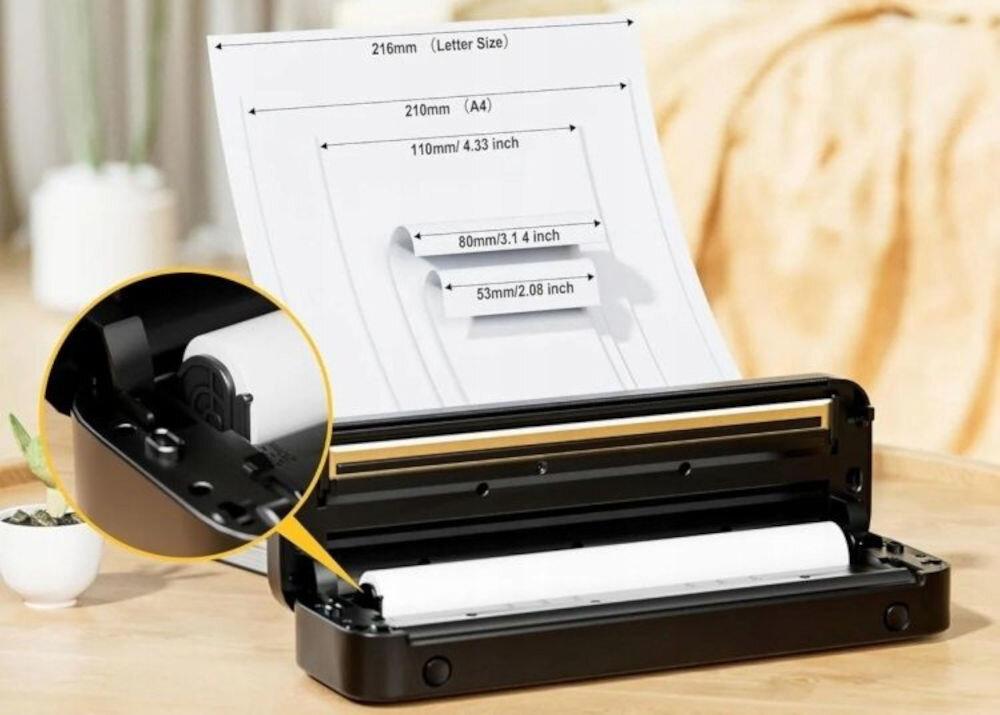 Drukarka PHOMEMO M832 Złącze USB fioletowy z myślą o mobilności, kompaktowe wymiary ok. 26,5 x7,5 x 3,5 cm, waga ok. 700 g, waga całkowita akumulatorem i papierem ok. 815 g produkt na blacie