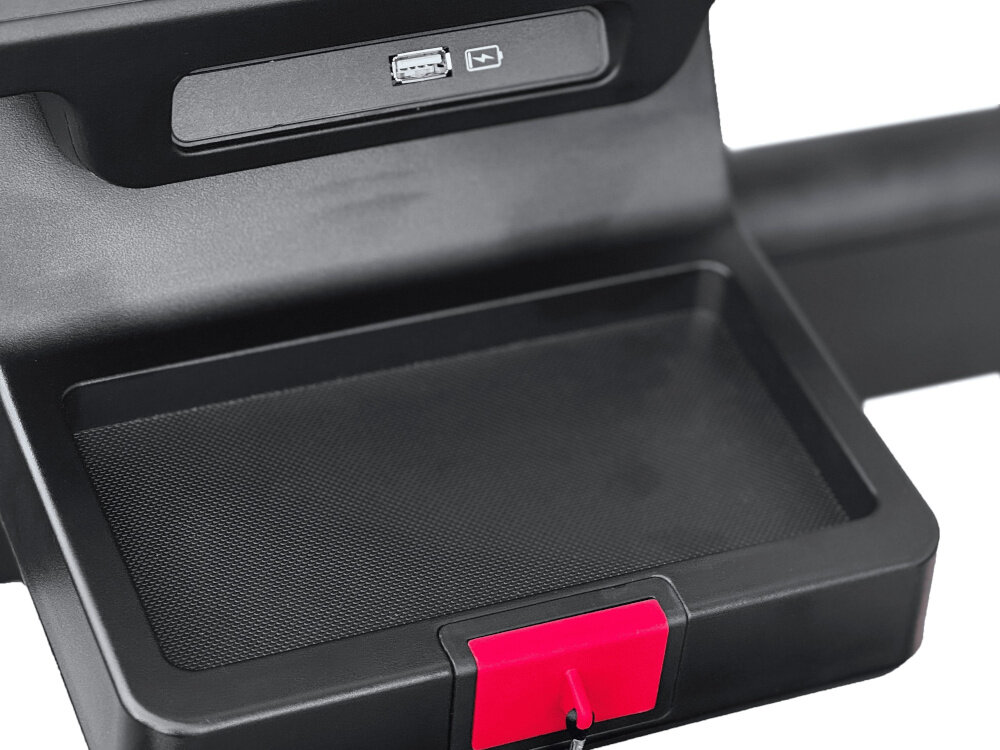 Czarna konsola z portem USB i symbolem ładowania, poniżej znajduje się płaska powierzchnia z czerwonym elementem na krawędzi.