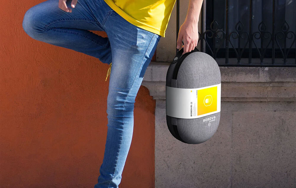 Etui BOBOVR C2 do gogli VR
 mężczyzna stojący i oparty o murek w dłoni trzymający etui